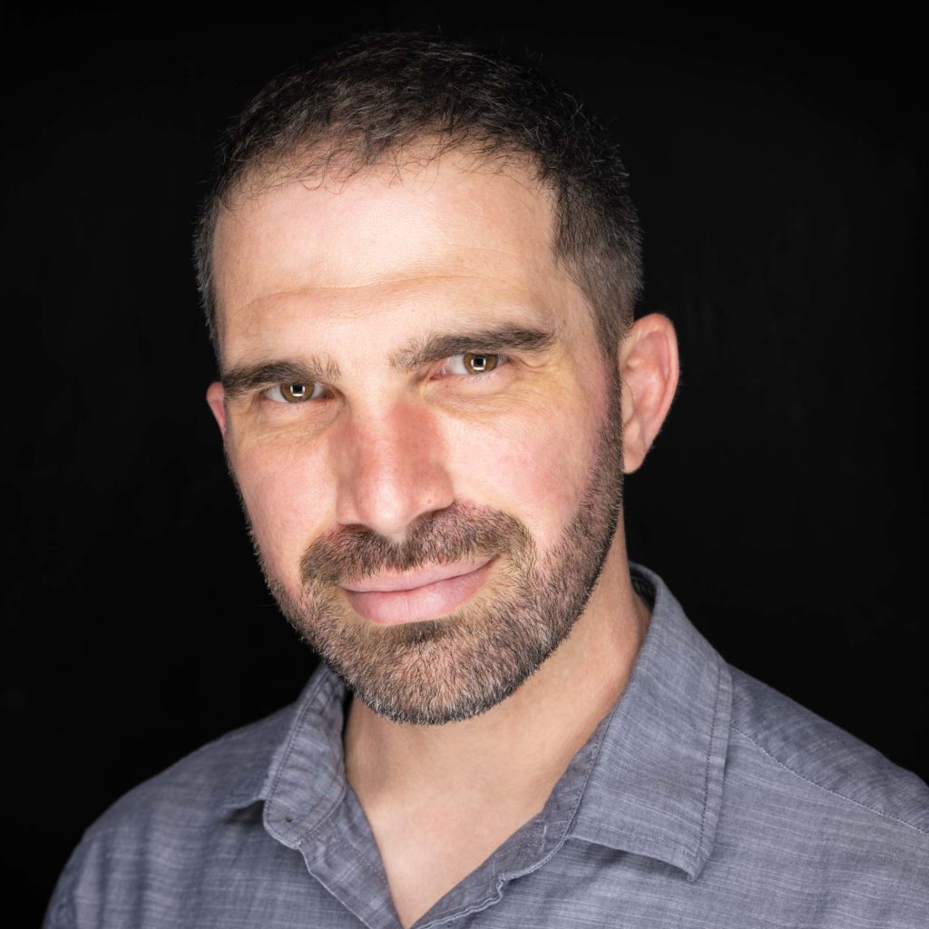 Headshot of portrait photographer Jason Guy on black background